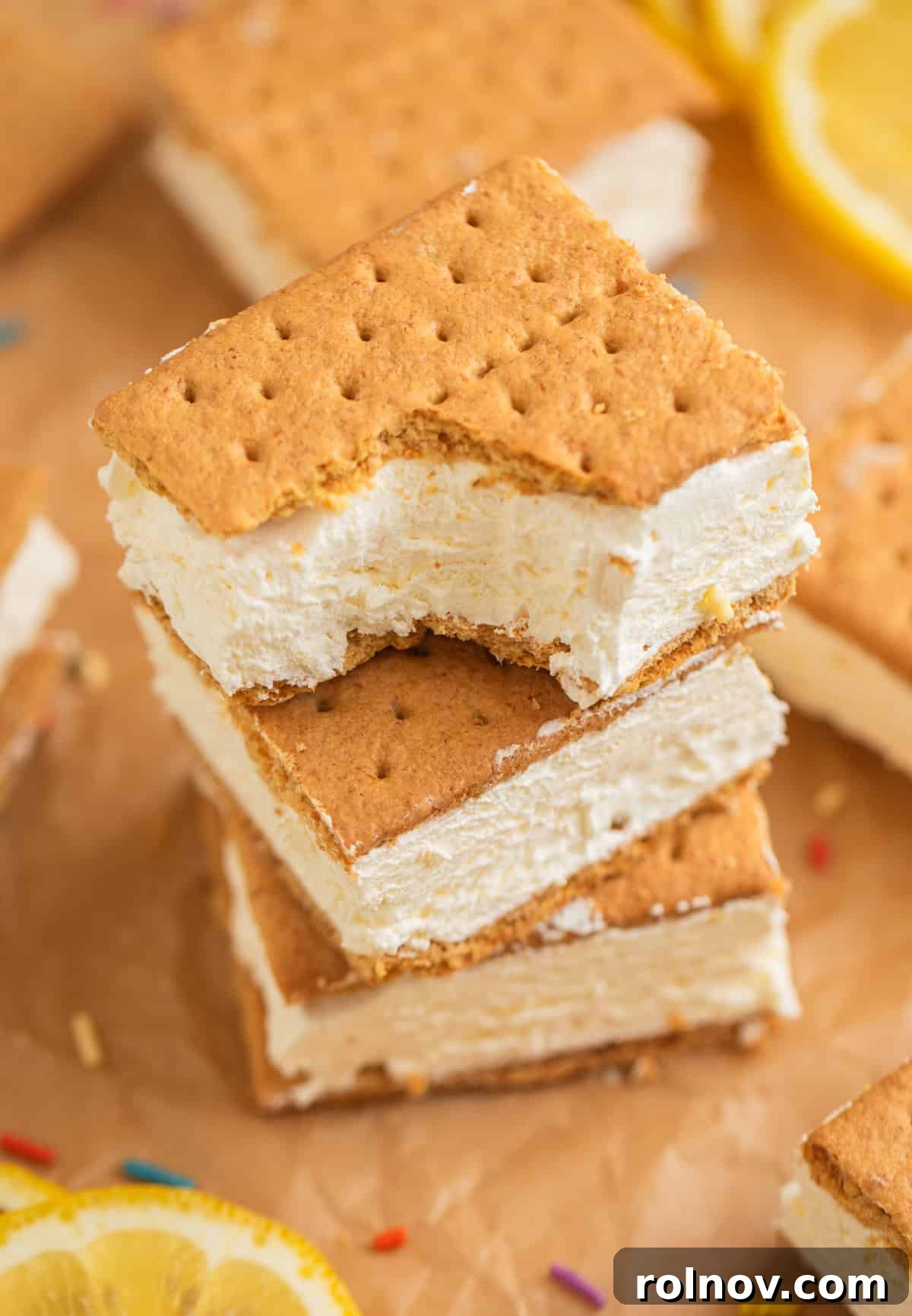 Lemonade Ice Cream Sandwich Recipe — Refreshing Citrus Treat 2 Lemonade ice cream sandwiches stacked on top of each other with bite taken out of the top.