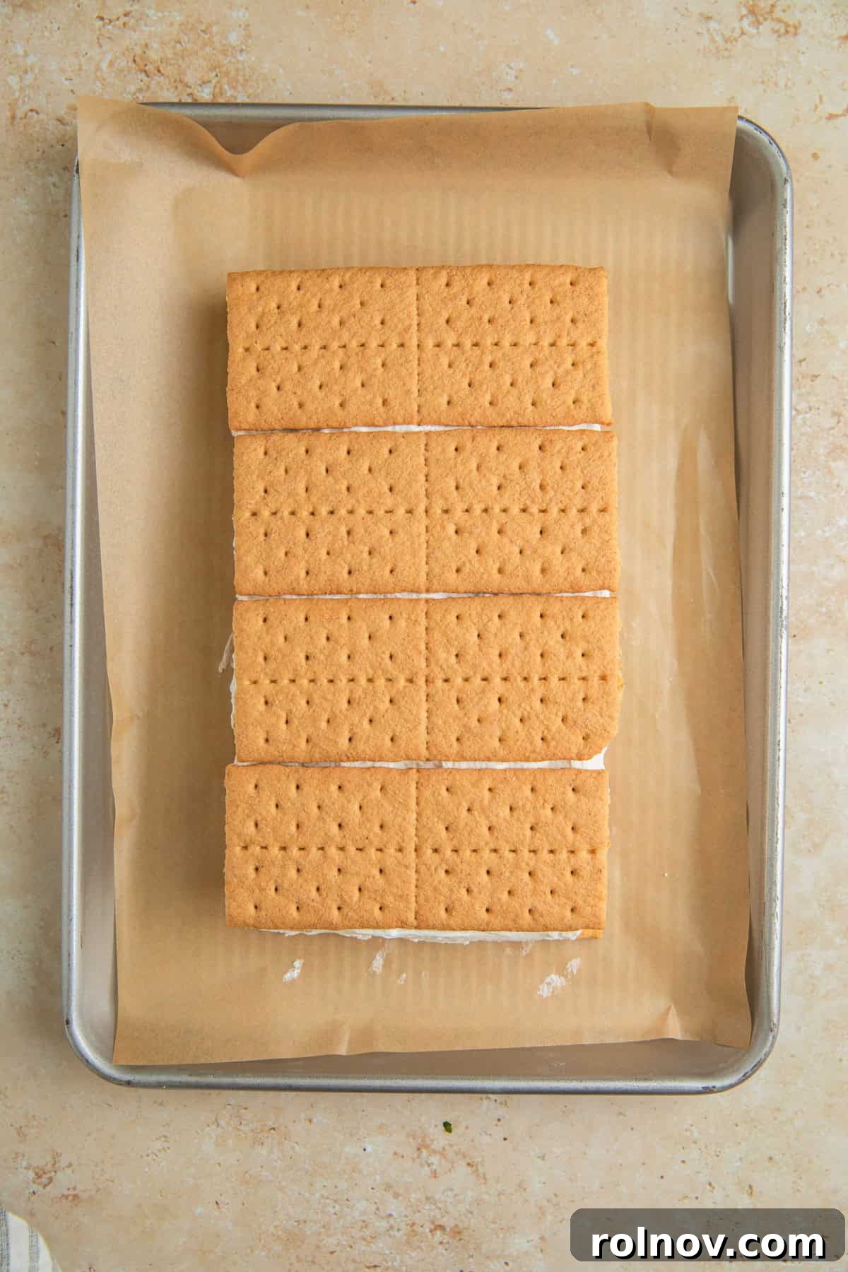 Lemonade Ice Cream Sandwich Recipe — Refreshing Citrus Treat 7 Graham crackers layered over top of lemonade whipped cream on pan with parchment.