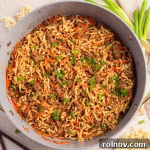 Pan with ground beef ramen topped with green onions.