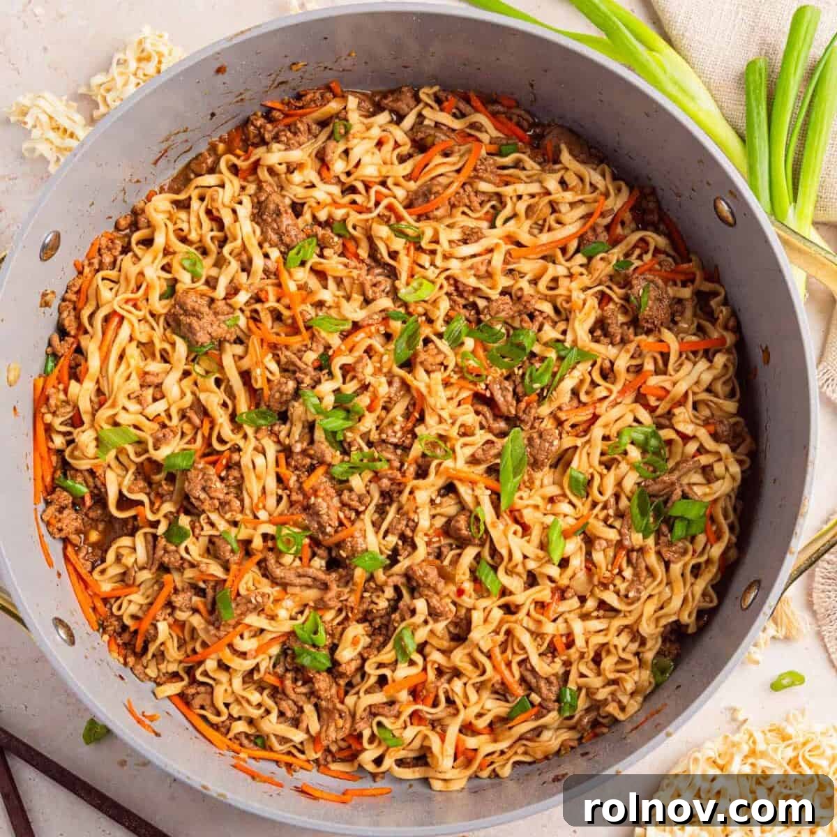 Pan with ground beef one-pot ramen topped with green onions.