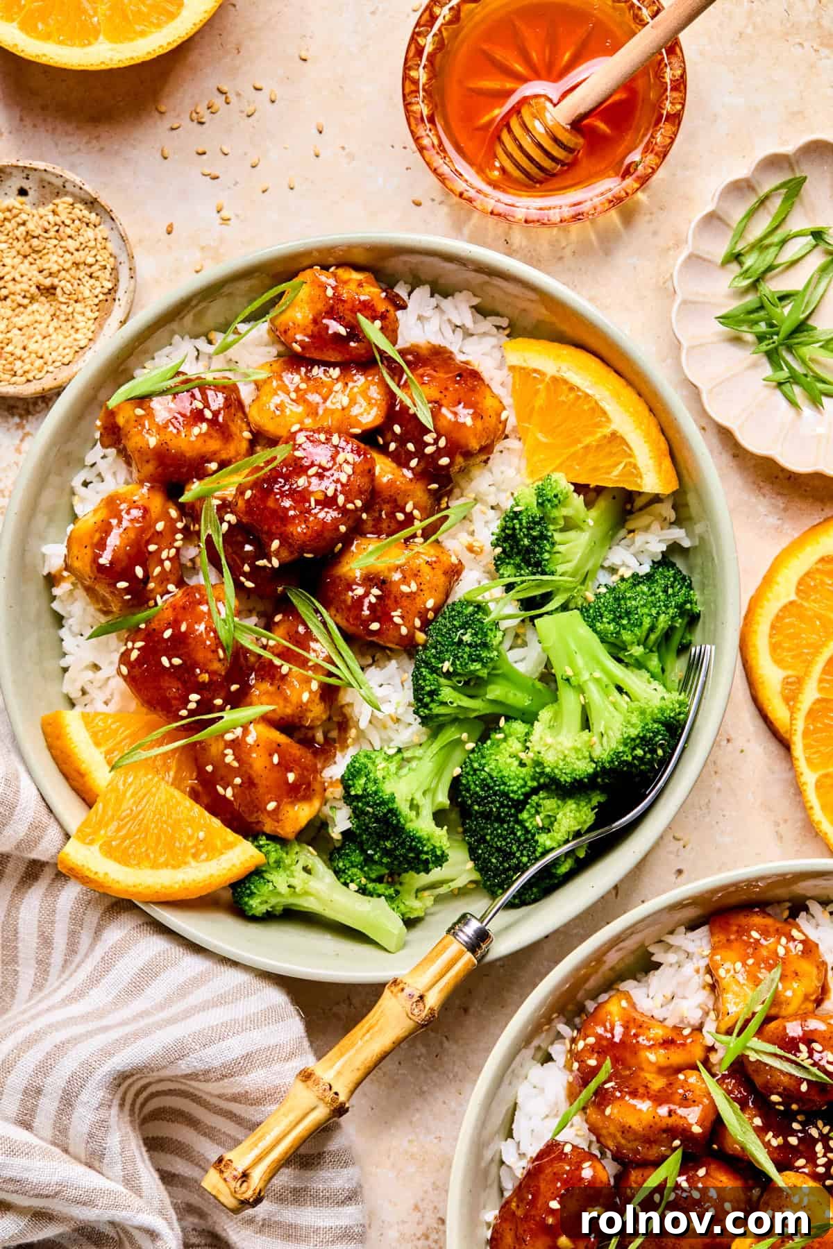 Spicy orange chicken in bowl with rice and broccoli.
