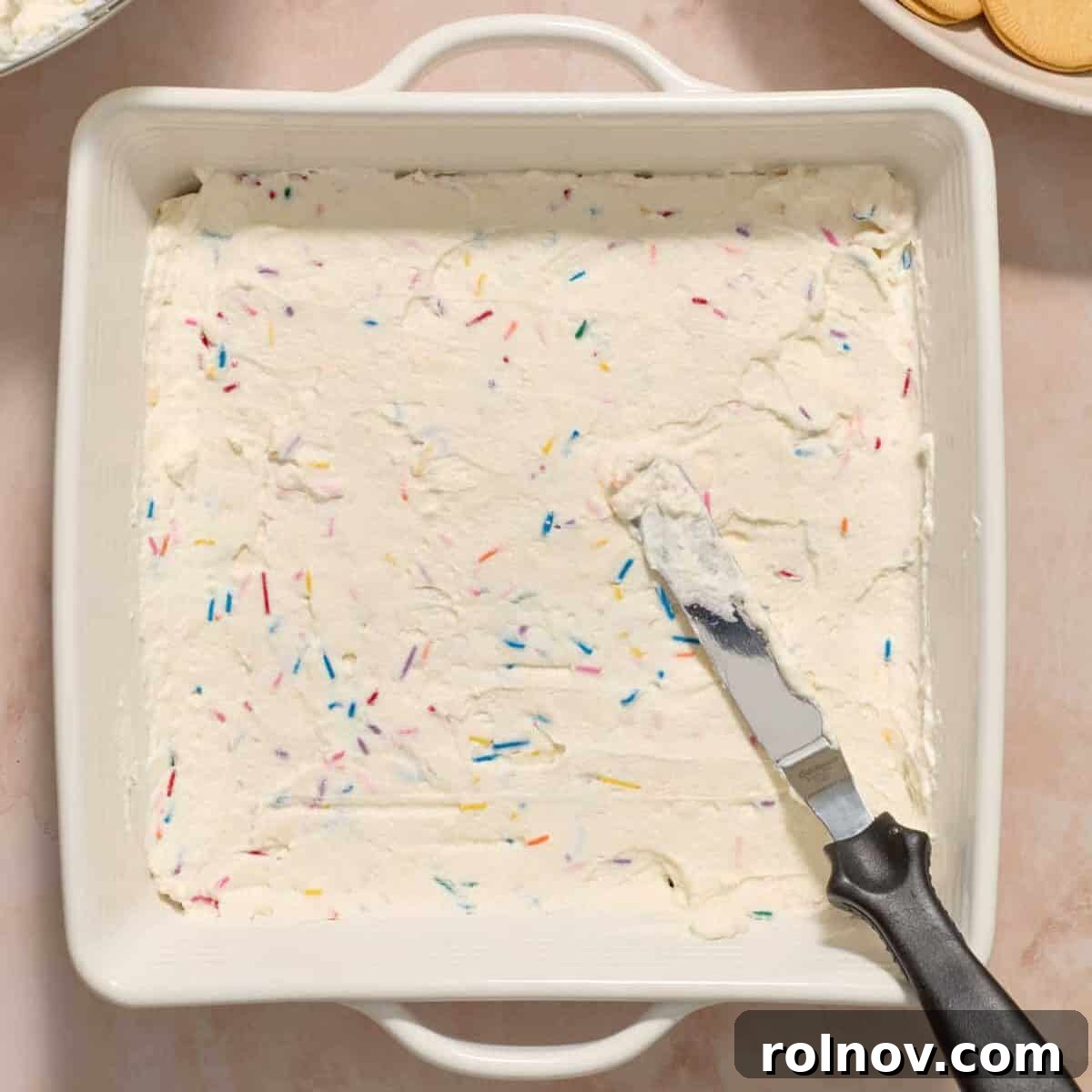 Spread funfetti cream cheese mixture over vanilla cookies with offset spatula.
