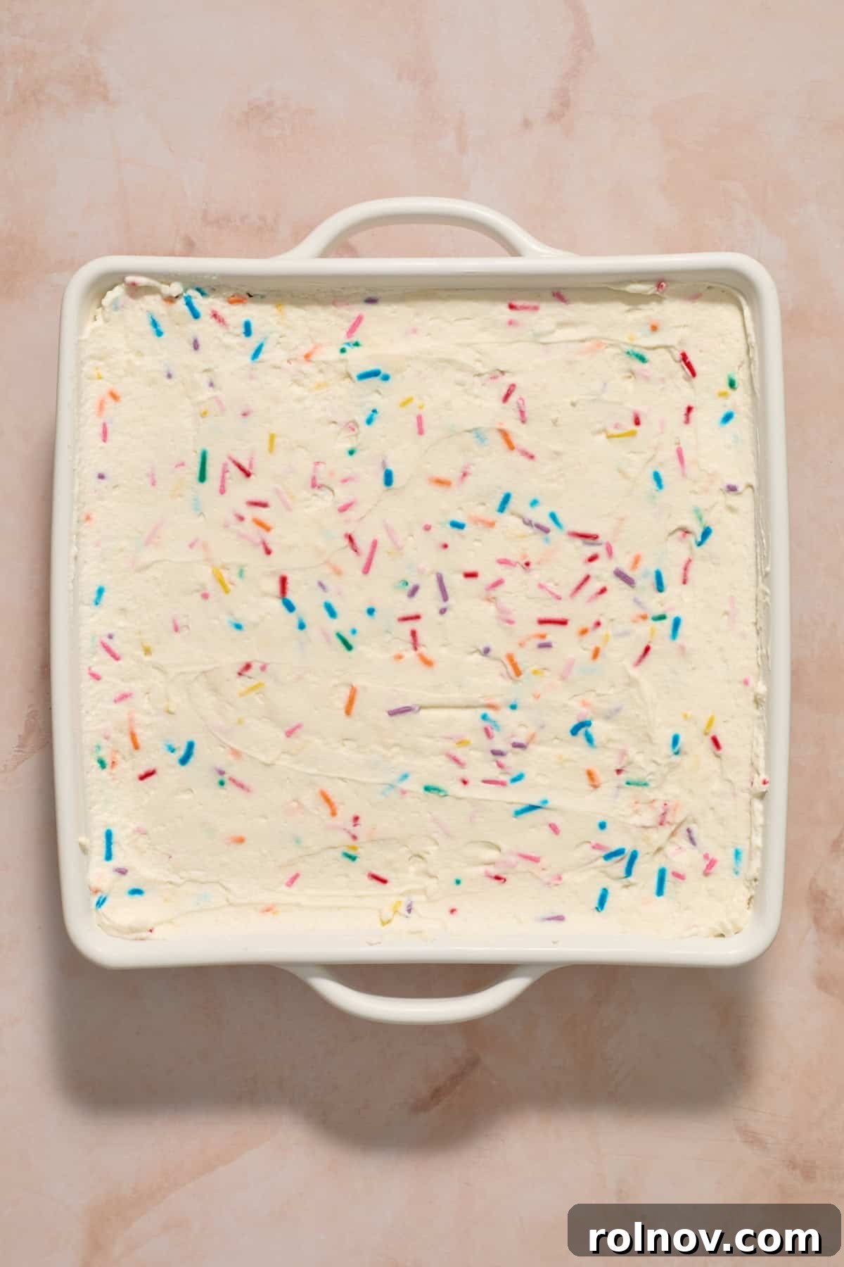 Chilled no-bake funfetti cake in white pan.