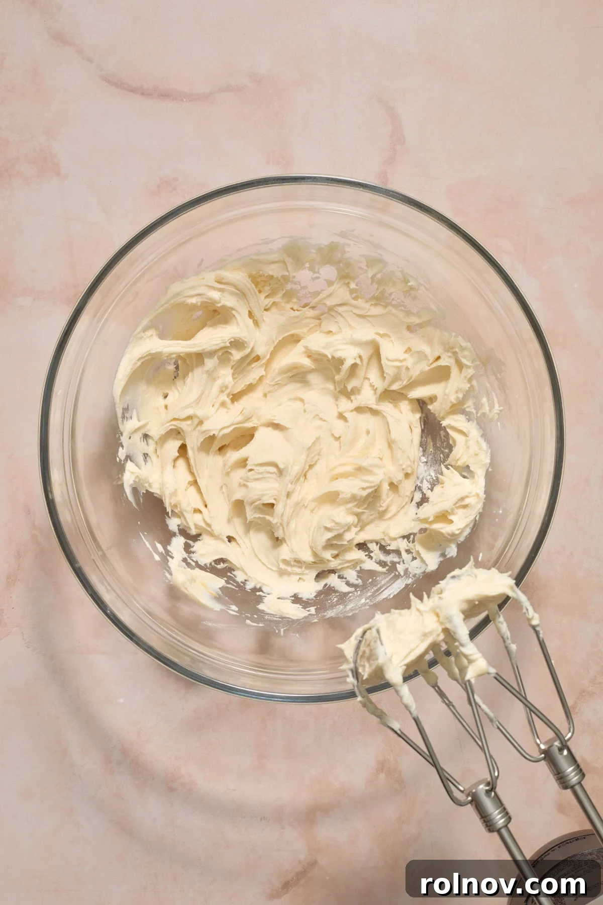 Cream cheese, powdered sugar and vanilla mixed in bowl.