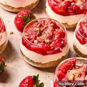 Roasted Strawberry Mini Cheesecake Cups Recipe 14 Dessert glass with layered strawberry topped cheesecake cups.