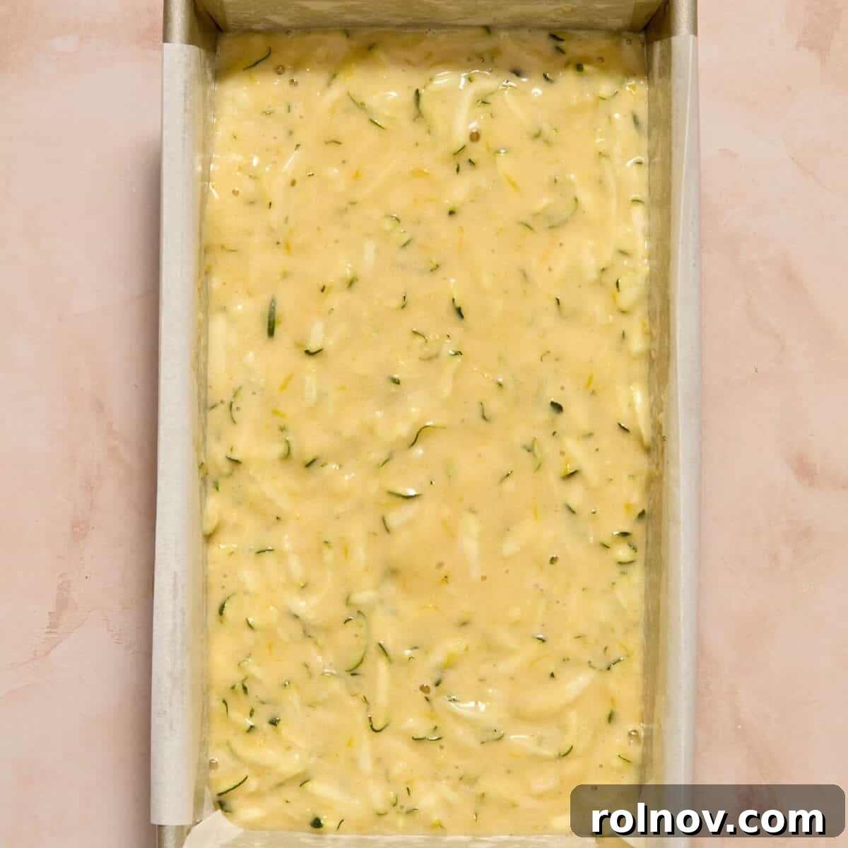 Moist Lemon Zucchini Bread with Citrus Glaze 10 Lemon zucchini bread batter in parchment lined bread pan.