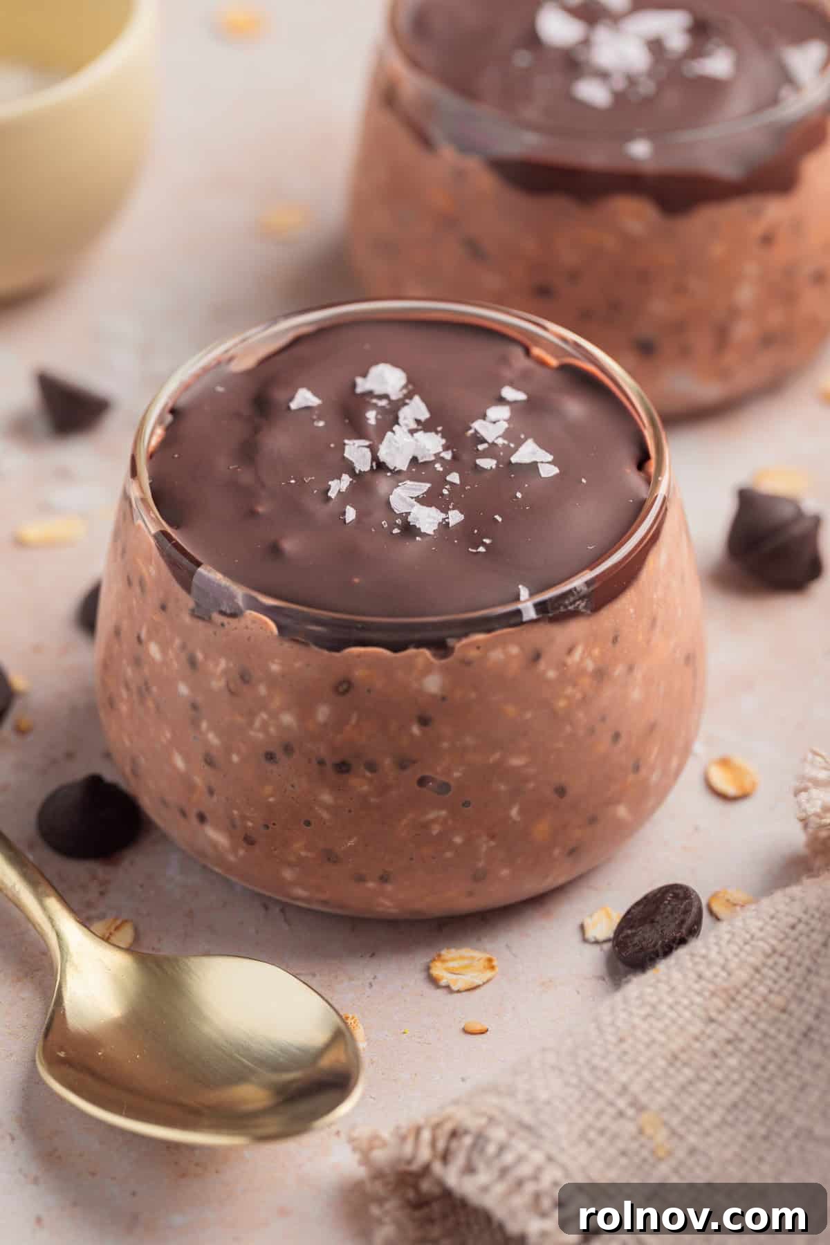 Chocolate oatmeal in dish topped with chocolate and sea salt.