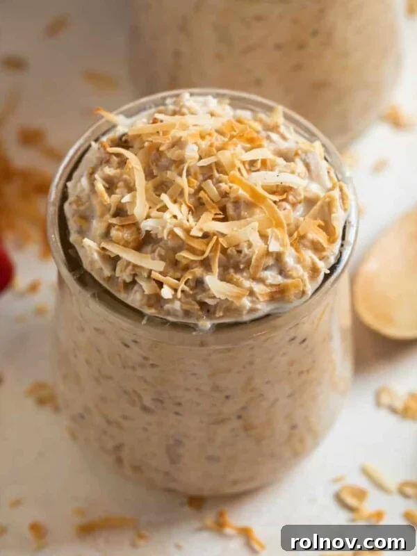 Coconut cream pie overnight oatmeal in a jar topped with toasted coconut.