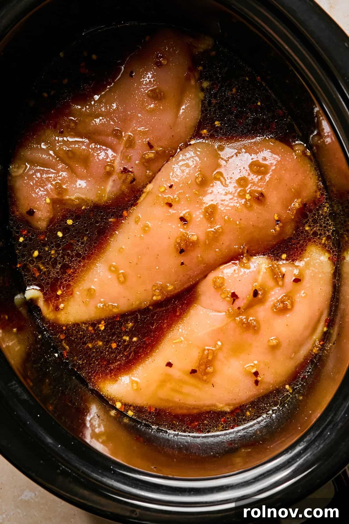 Sticky Honey Sriracha Slow Cooker Chicken 7 Honey garlic sriracha sauce poured over chicken breasts before cooking.