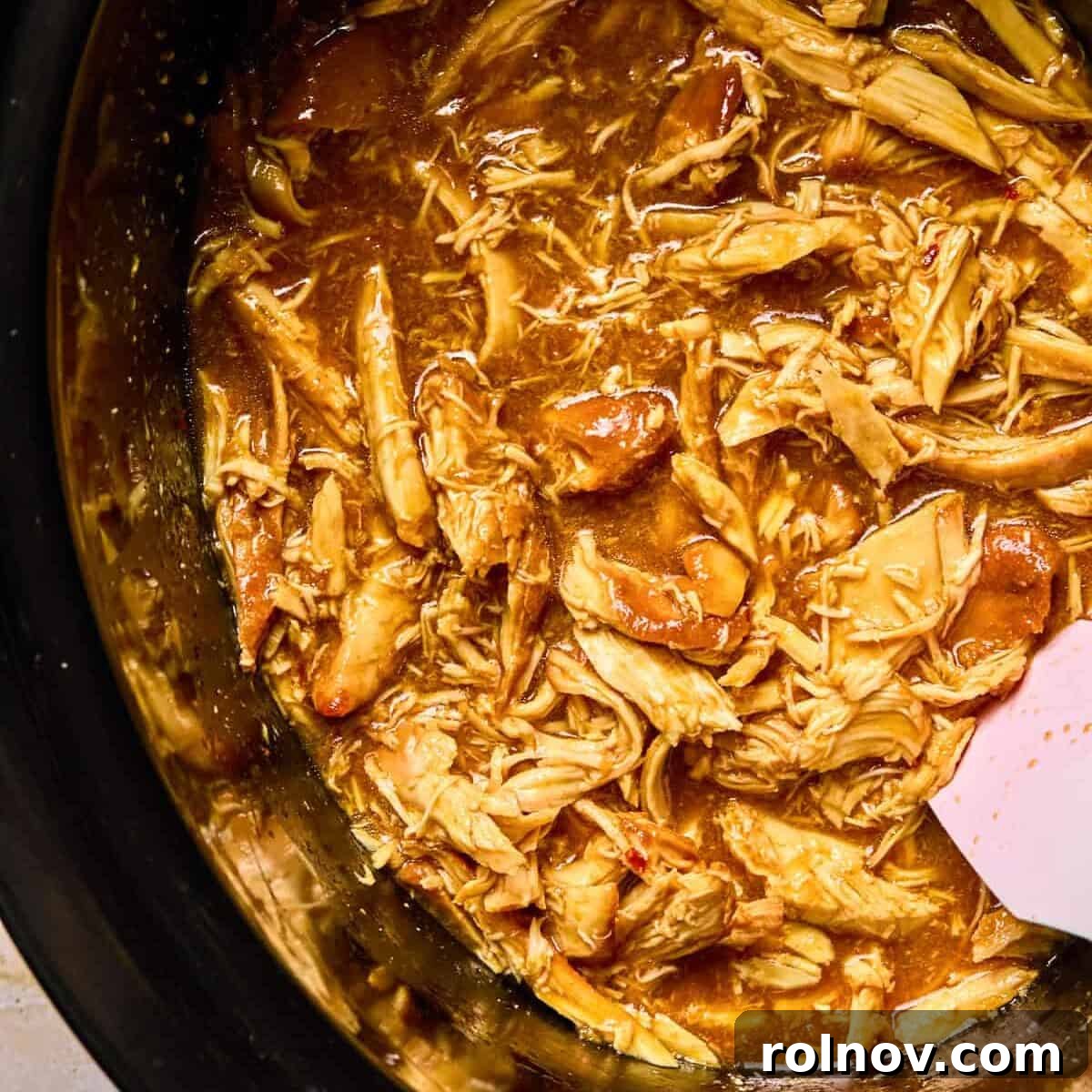 Sticky Honey Sriracha Slow Cooker Chicken 10 Crockpot honey sriracha shredded chicken in pot.