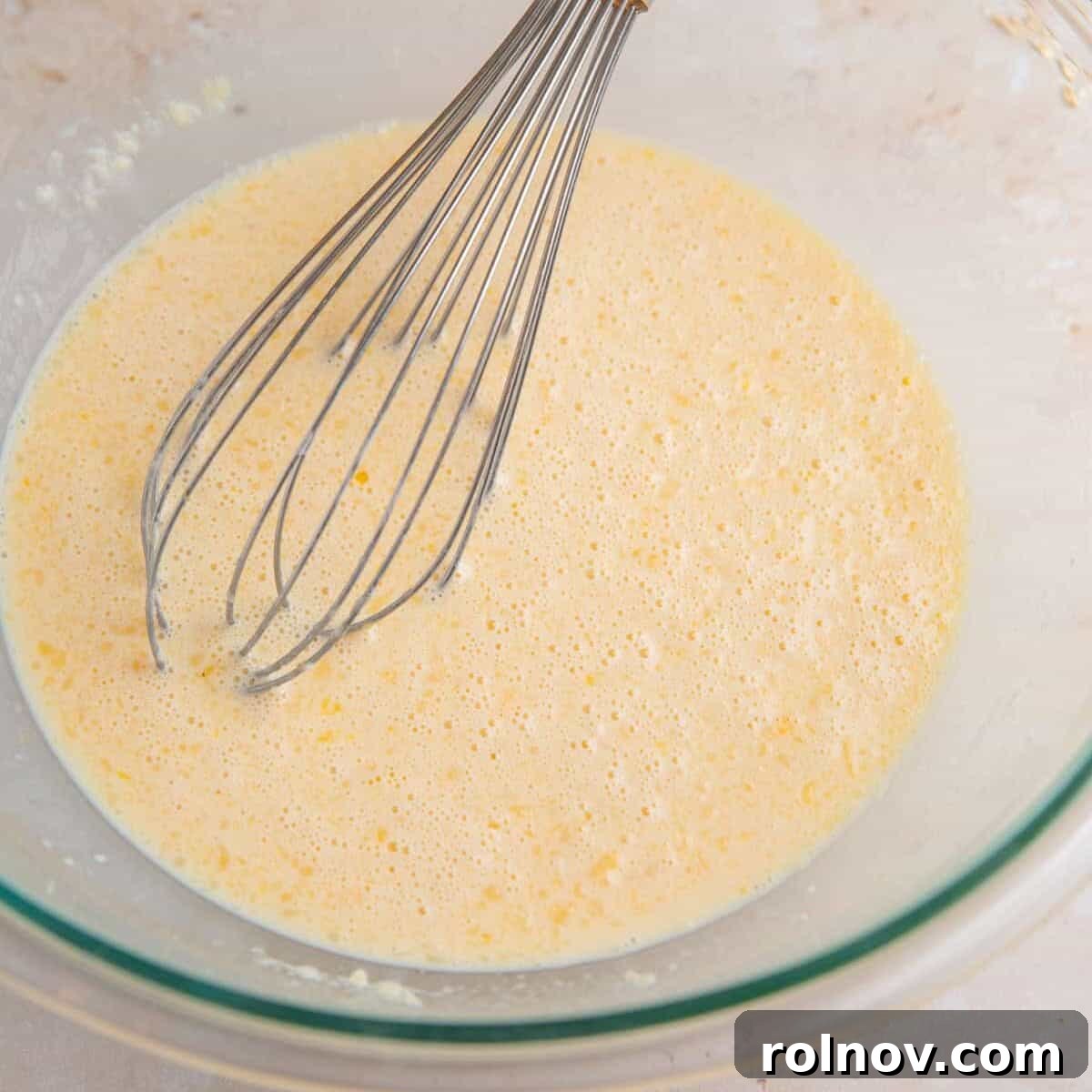 Wet ingredients mixed in bowl with whisk.