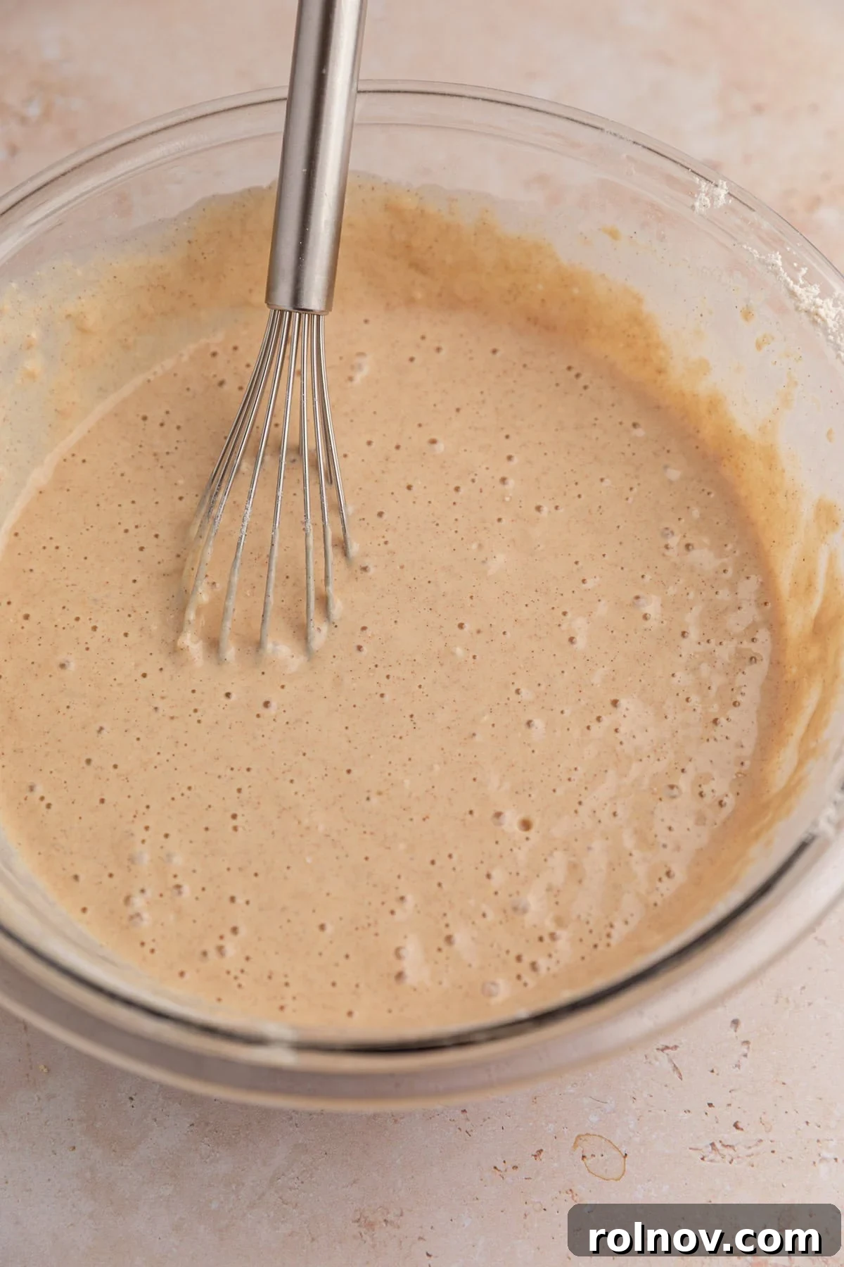 Sheet-Pan Apple Pancakes with Cinnamon 6 Dry ingredients mixed into wet in pancake batter in bowl.