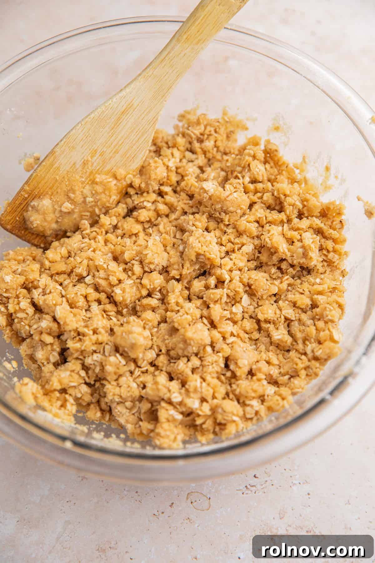 Crumble oat mixture in bowl with spoon.