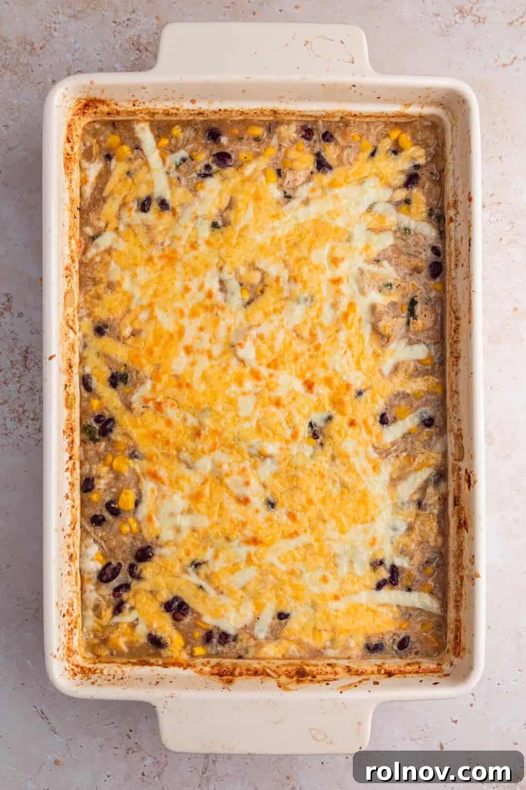 Baked salsa verde chicken and rice with cheese on top.
