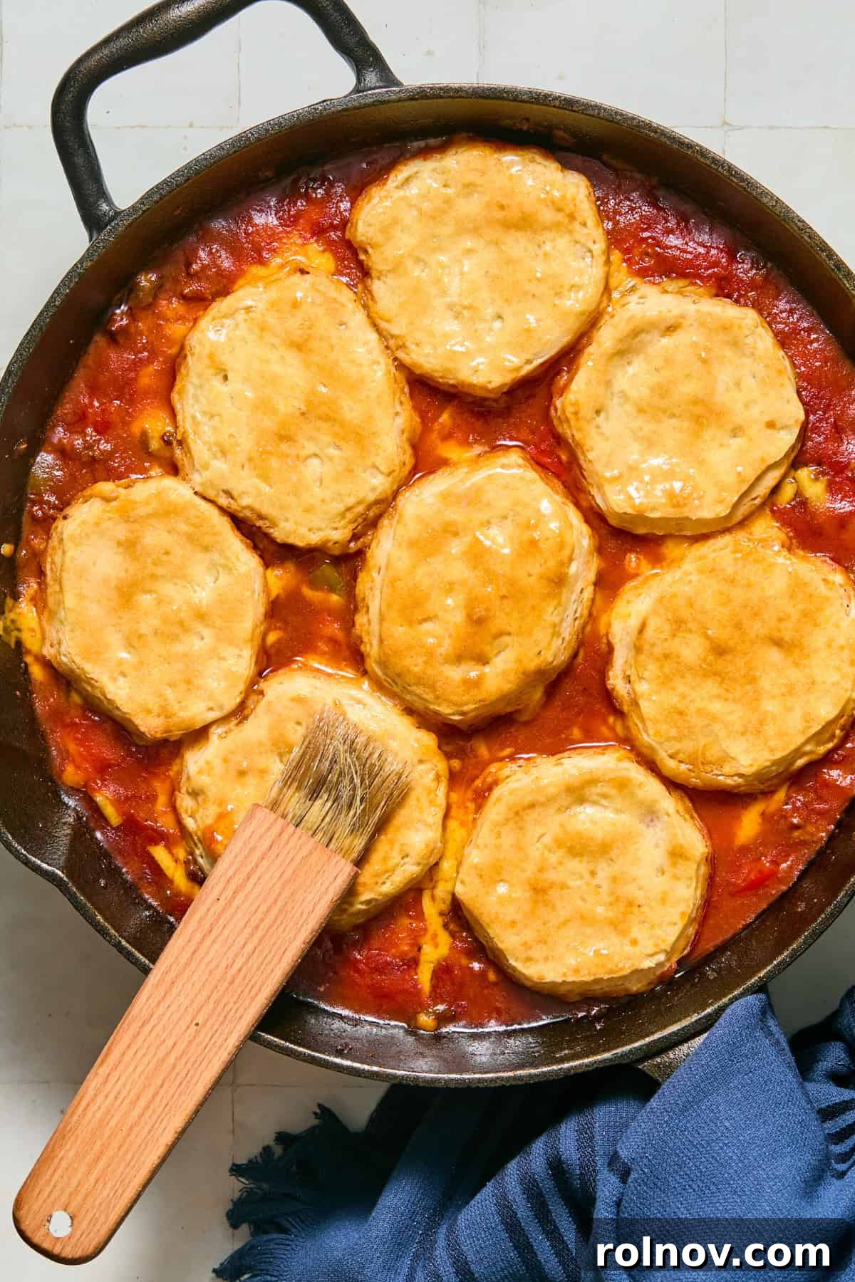Cheesy Sloppy Joe Casserole for Family Weeknight Dinners 11 Biscuit tops brushed with butter over casserole in skillet.
