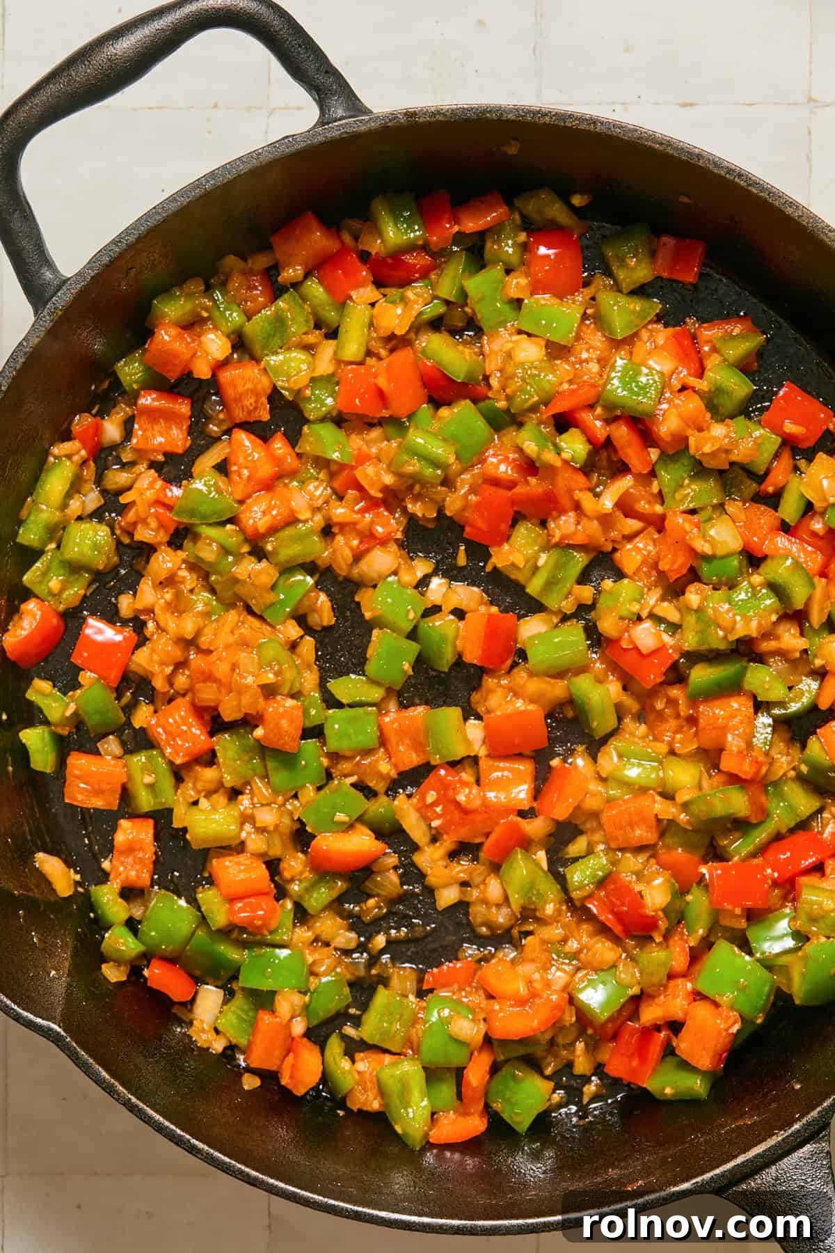 Cheesy Sloppy Joe Casserole for Family Weeknight Dinners 7 Sautéed onions and peppers in cast iron skillet.
