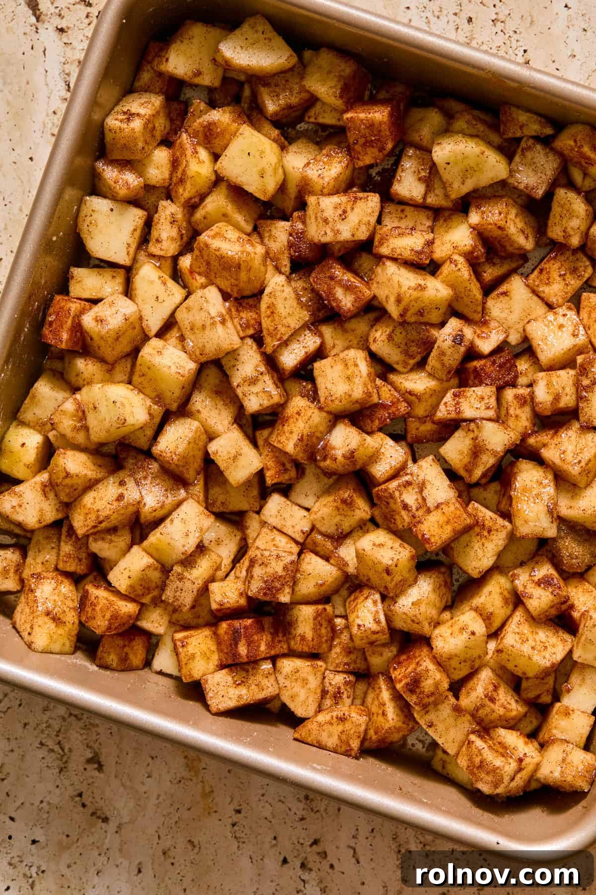 Cinnamon apples in square baking pan.