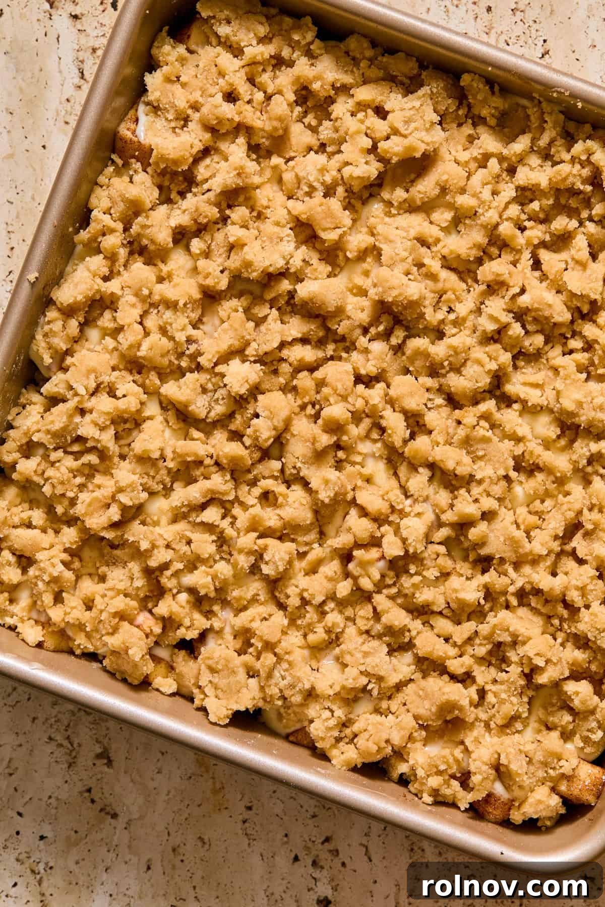 Cobbler mixture sprinkled over apples and cream cheese.