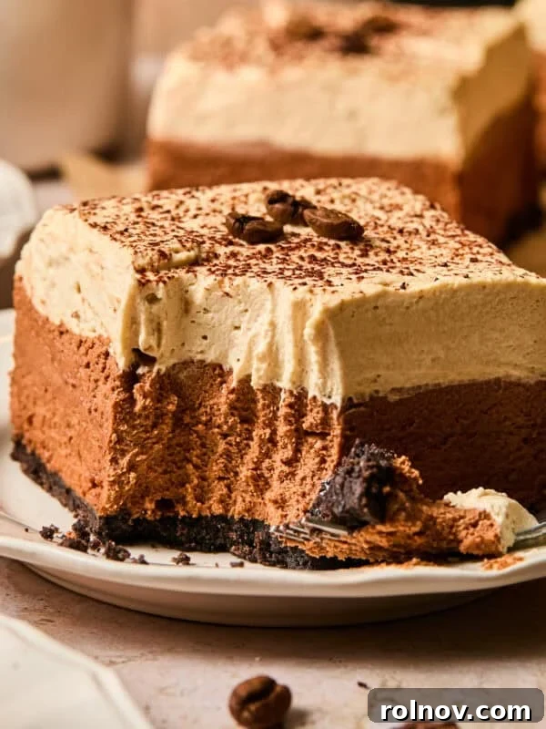 Layered espresso martini no bake bar on plate with forkful taken out.
