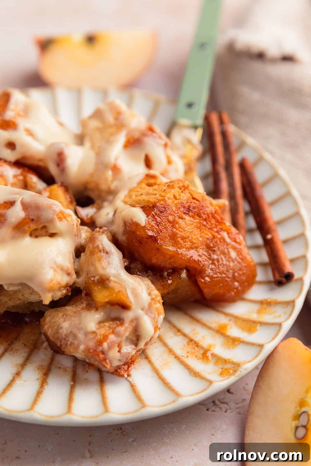 Warm Apple Cinnamon Biscuit Casserole 10 Plate with gooey apple cinnamon biscuit bake with fork.