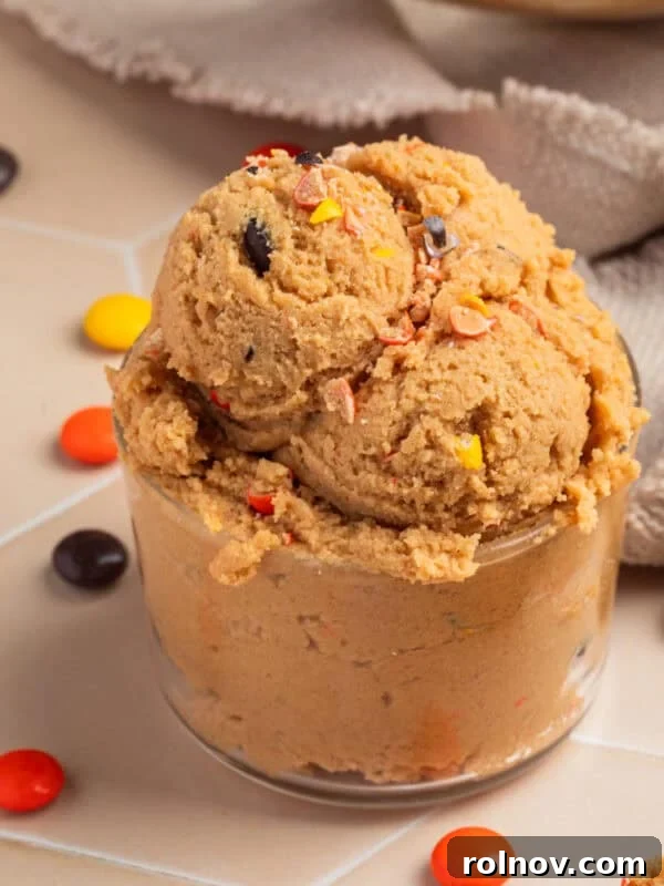 Glass with edible peanut butter cookie dough scooped into it.