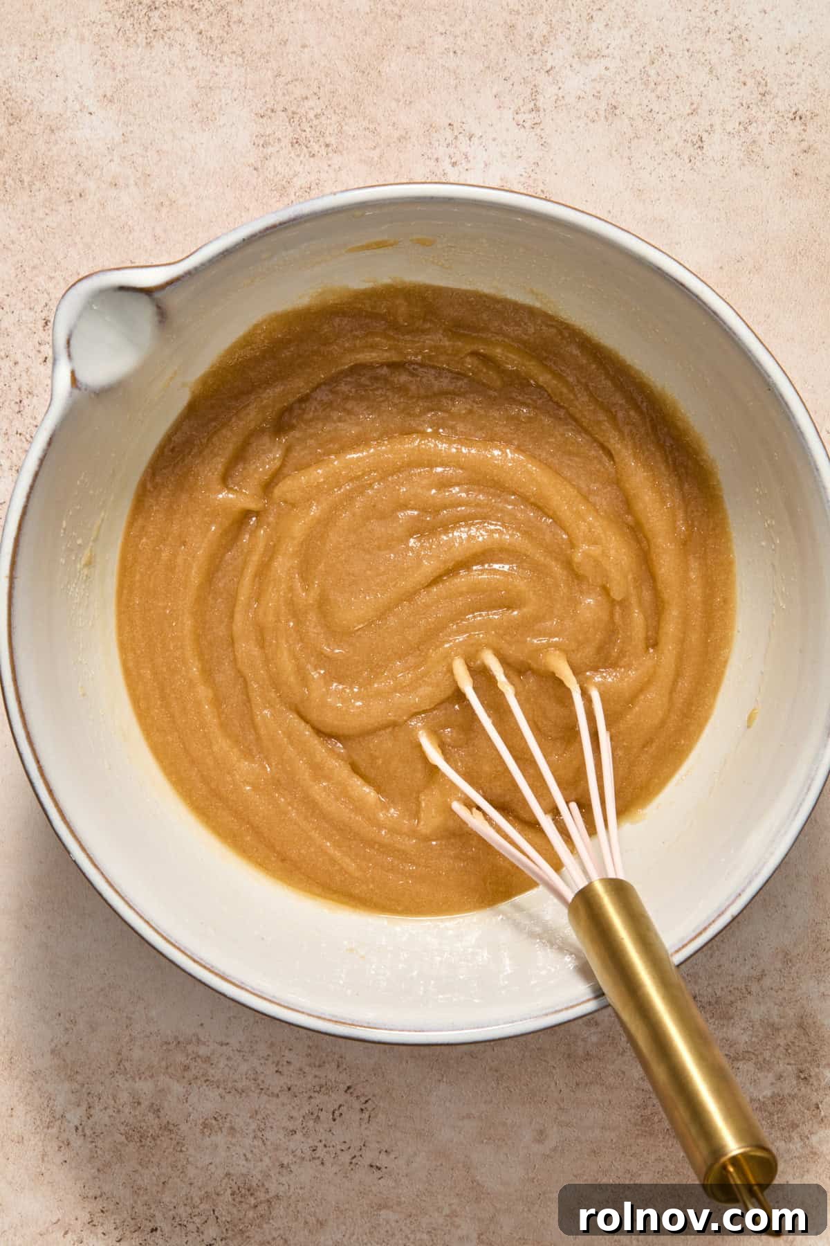 Sugars and butter mixed in bowl with whisk.