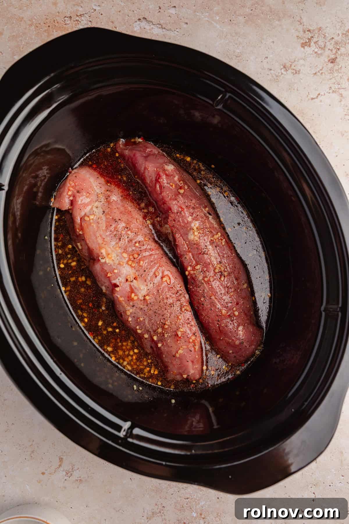 Honey Garlic Pork Tenderloin in the Slow Cooker 6 Crockpot with pork tenderloins and sauce before cooking.
