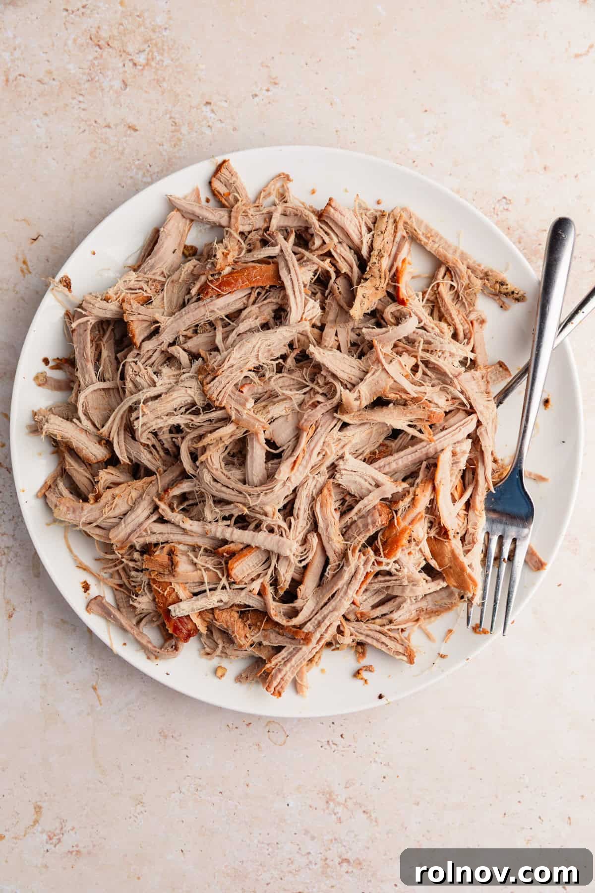 Honey Garlic Pork Tenderloin in the Slow Cooker 9 Pulled pork tenderloin on plate with forks.