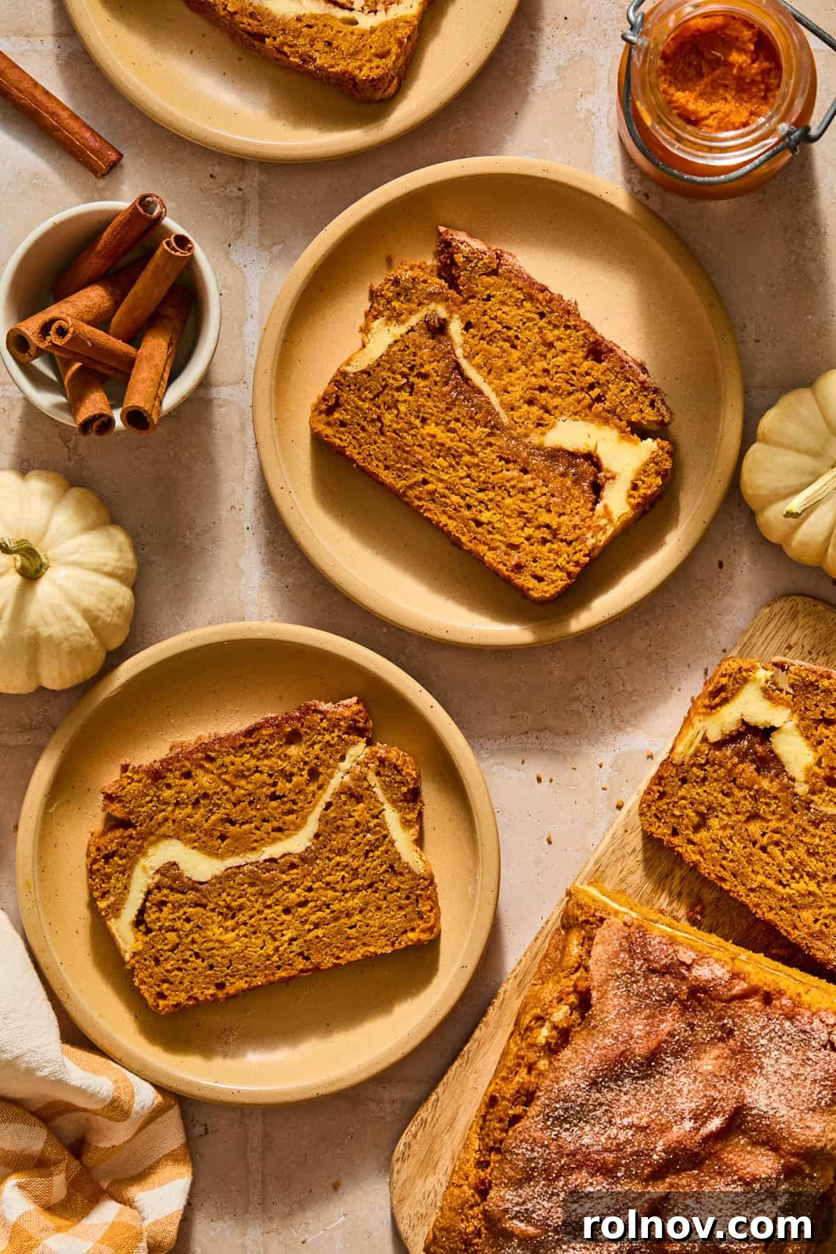 Cinnamon Pumpkin Bread with Cream Cheese Swirl 2 Slices of pumpkin bread with cinnamon sugar and cream cheese swirl on plates.