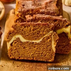 Cinnamon Pumpkin Bread with Cream Cheese Swirl 15 Pumpkin bread sliced on cutting board with cream cheese and cinnamon swirl in center.